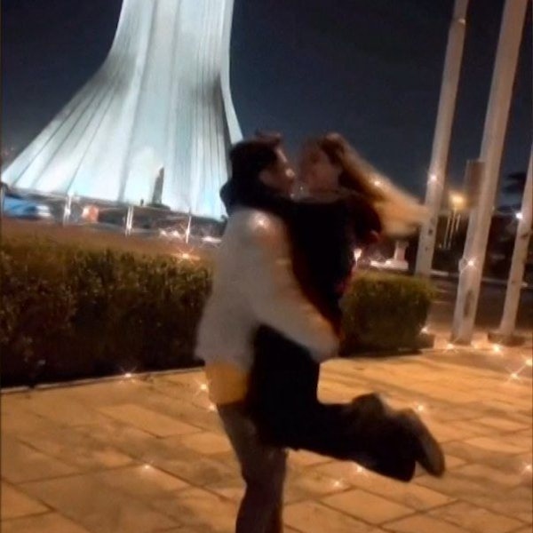 Ein junges Paar tanzt und umarmt sich vor Freiheitsturm in Teheran.