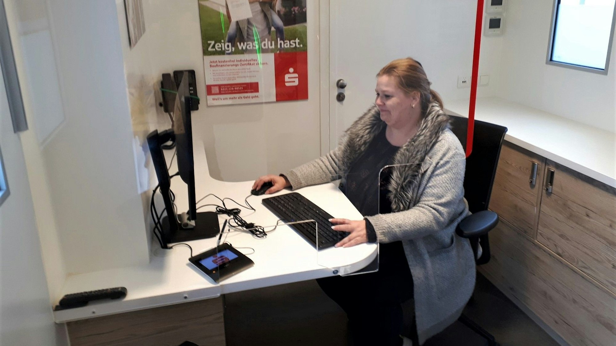 Eine Mitarbeiterin des Sparkassenbus sitzt an ihrem Arbeitsplatz.