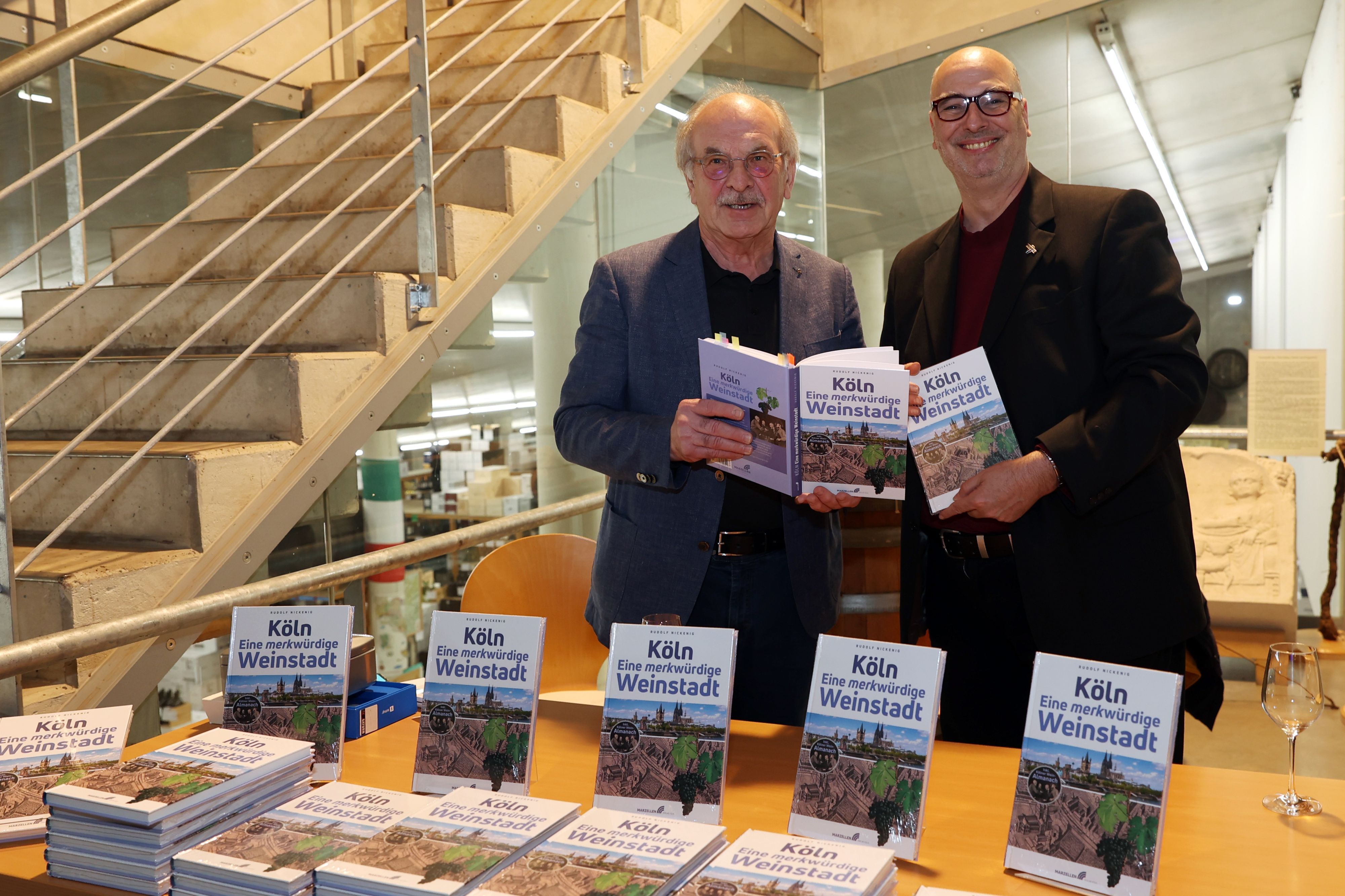 Rudolf Nickenig und Frank Tewes vom Marzellen Verlag halten beide ein Exemplar des neuen Buchs in den Händen.
