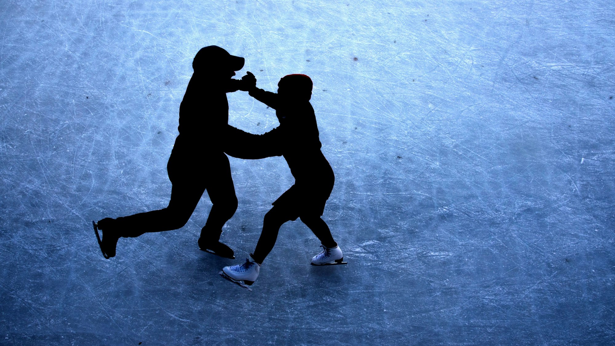 Ein Pärchen mit Schlittschuhen auf dem Eis