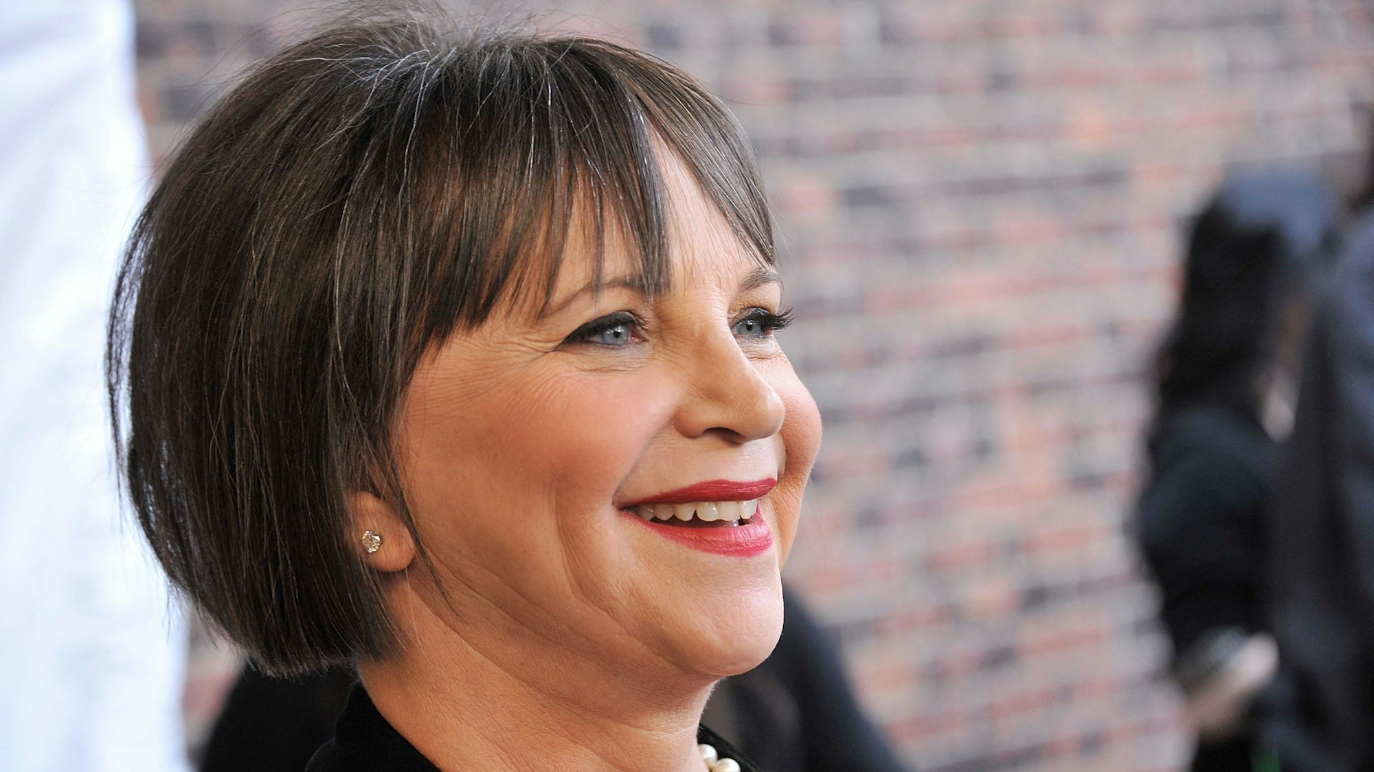 Man sieht Cindy Williams von der Seite in Nahaufnahme, sie lächelt.