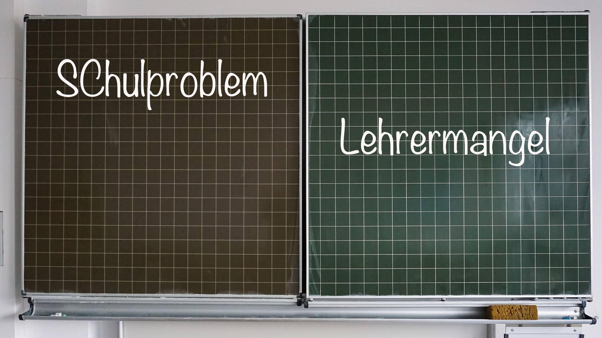 Auf einer Schultafel stehen rechts der Begriff „Lehrermangel“ und links „Schulproblem“, beides in Kreideschrift.