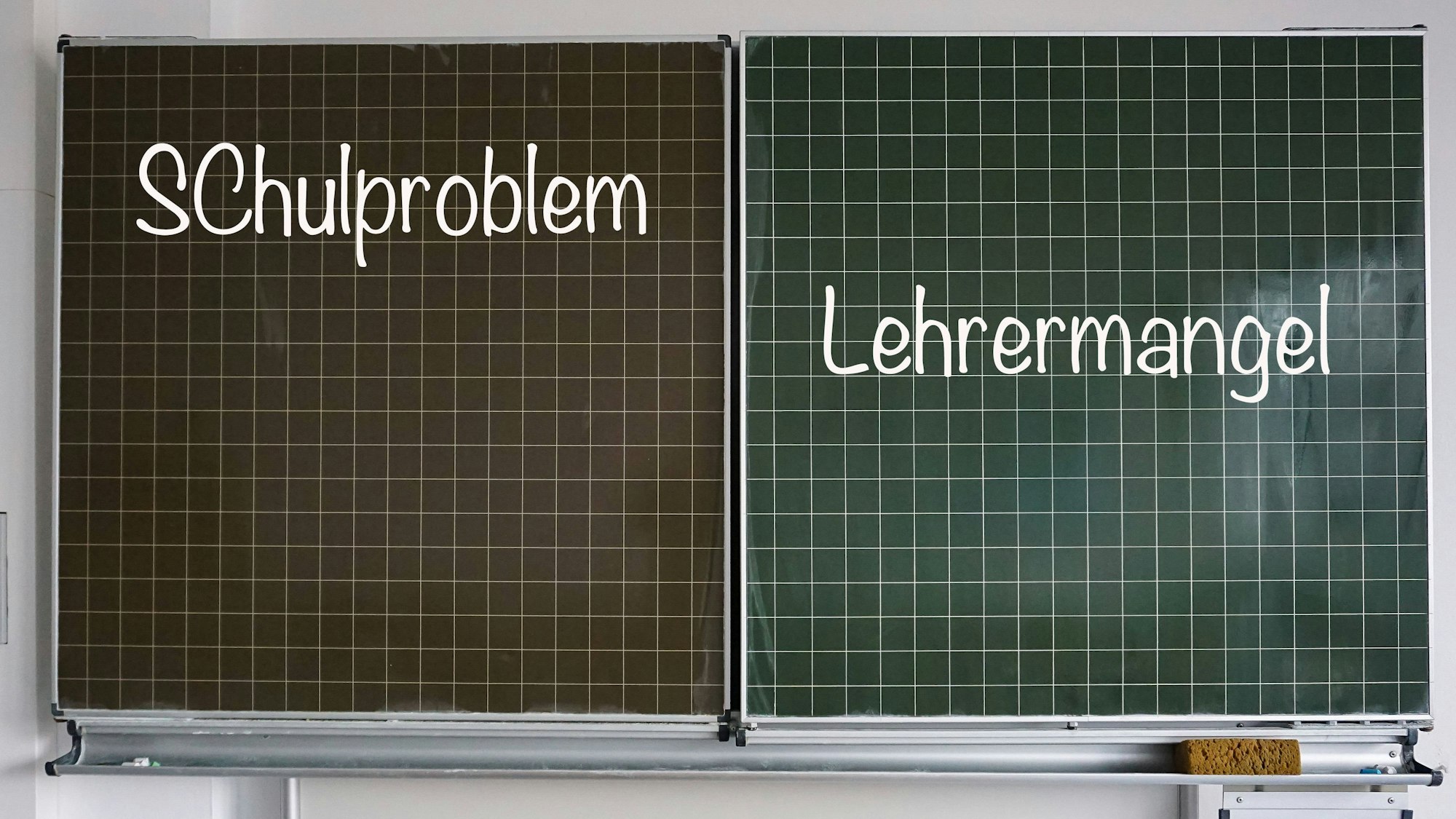 Auf einer Schultafel stehen rechts der Begriff „Lehrermangel“ und links „Schulproblem“, beides in Kreideschrift.
