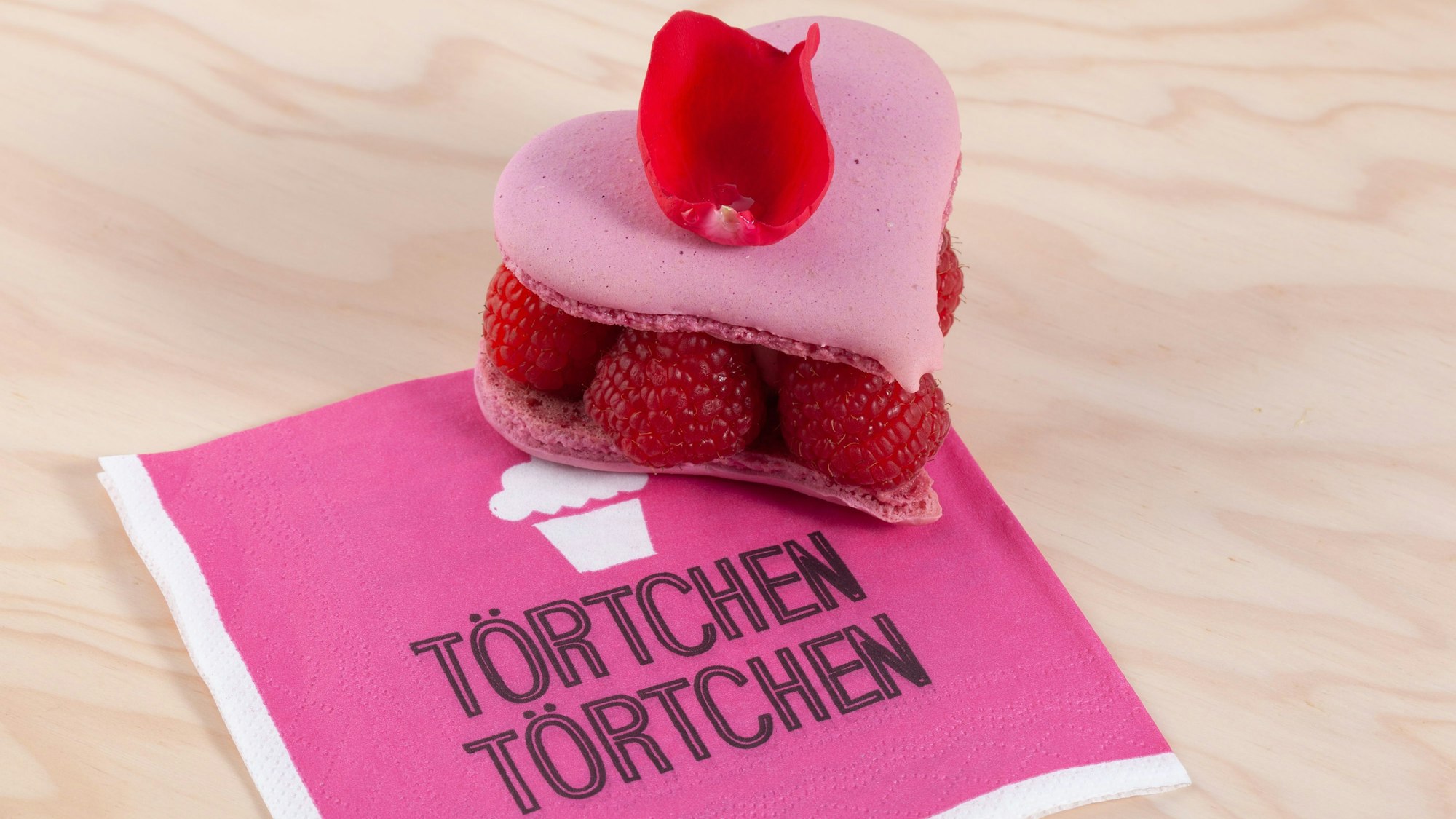 pinkes Törtchen in Herzform auf einer Serviette
