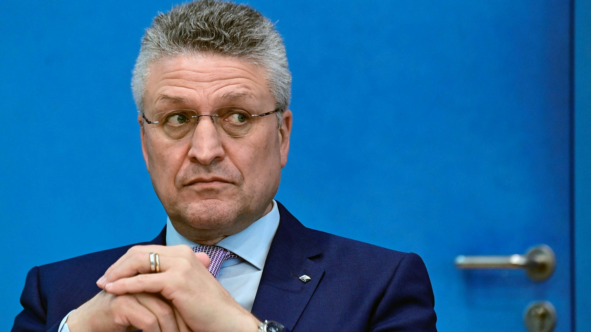 Der ehemalige Präsident des Robert-Koch-Instituts, Lothar Wieler, blickt vor einer blauen Tür nach rechts.