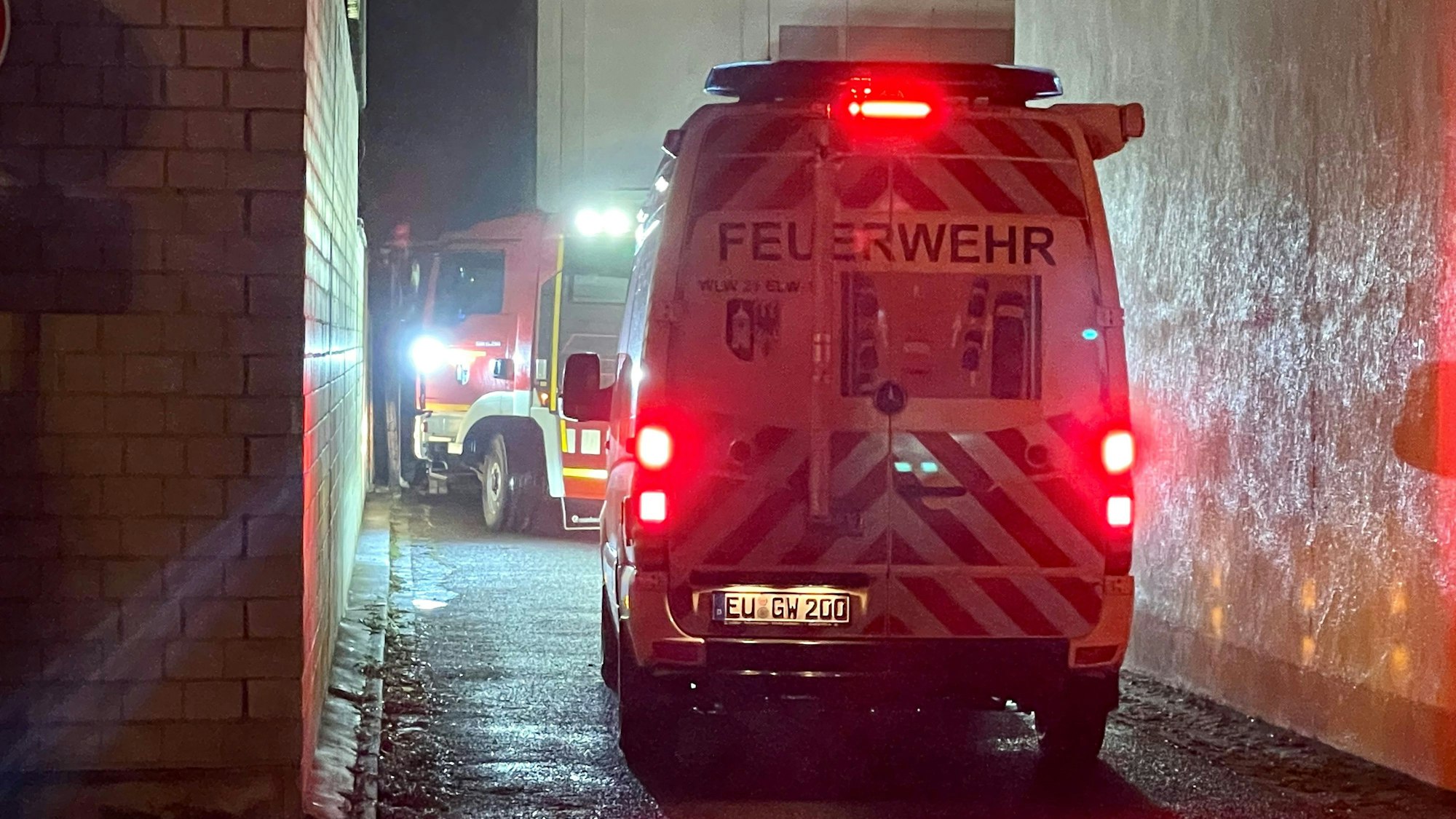 Das Bild zeigt ein Feuerwehrfahrzeug, wie es im Dunkeln in Lommersum zum Gerätehaus fährt. Die Einfahrt ist recht eng.