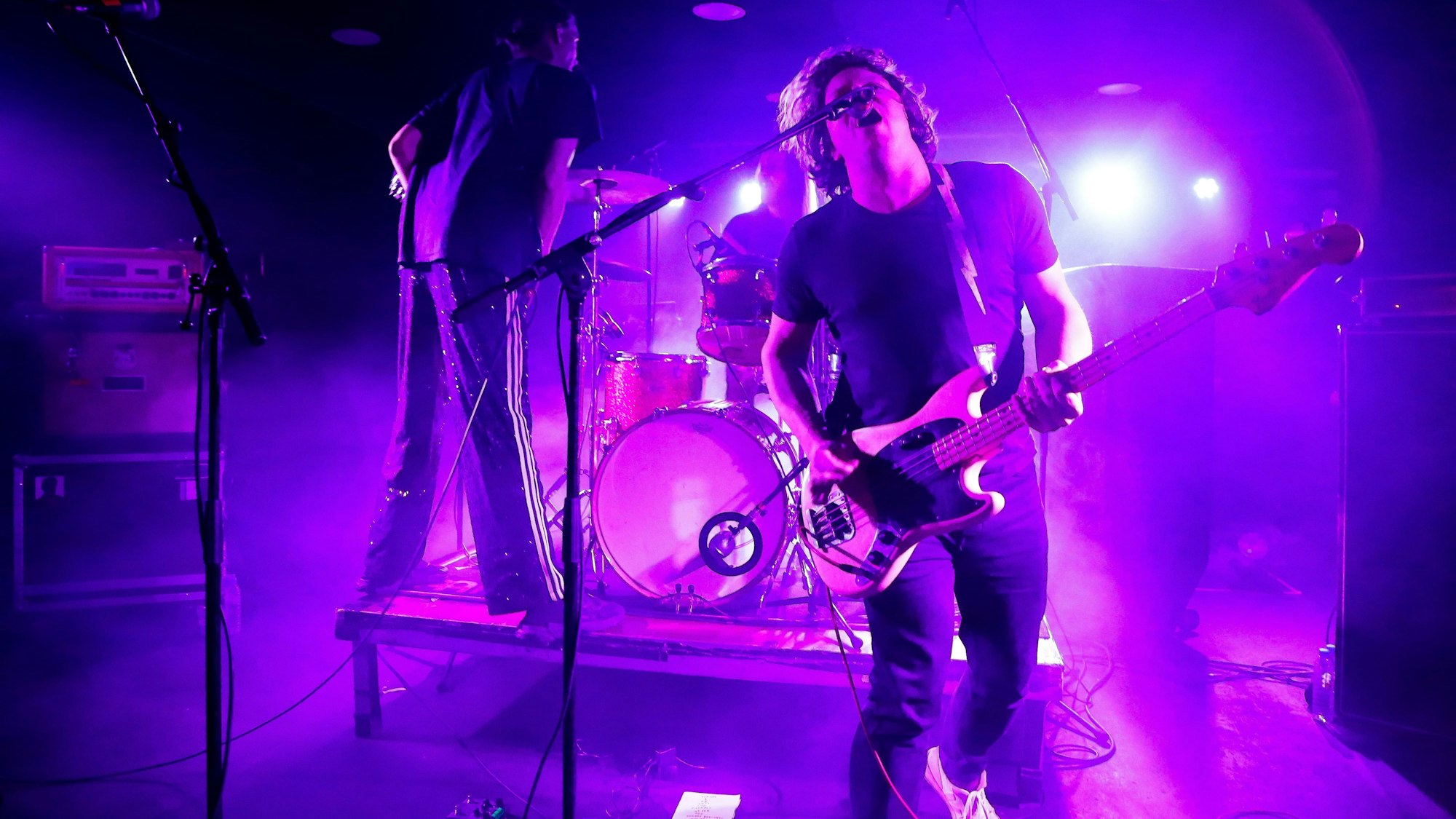 Bassist Julian Knoth von der deutschen Noiserock-Band Die Nerven brüllt ins Mikrofon. Gitarrist Max Rieger steht im Kölner Luxor auf dem Schlagzeug-Podest von Drummer Kevin Kuhn.