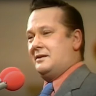 Jonny Buchardt steht grinsend am Mikrophon.