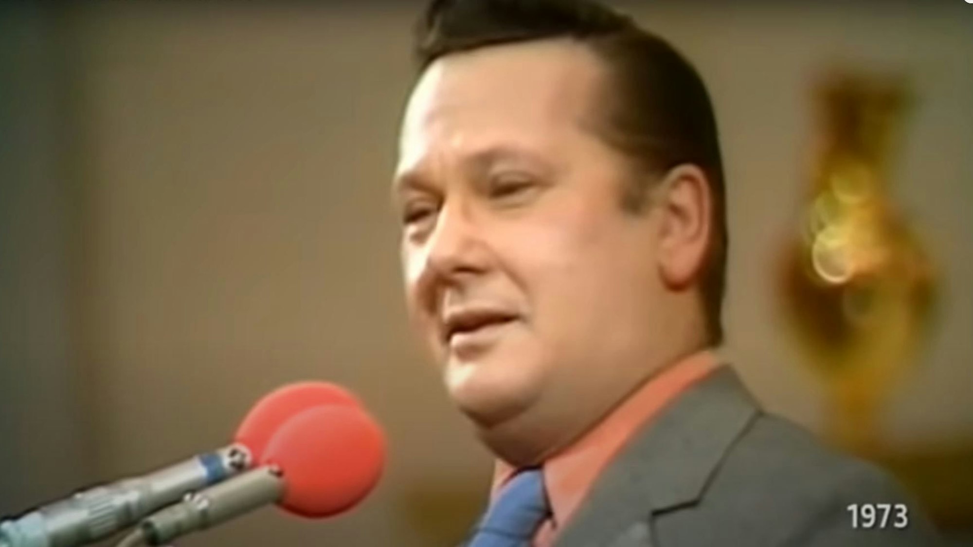 Jonny Buchardt steht grinsend am Mikrophon.