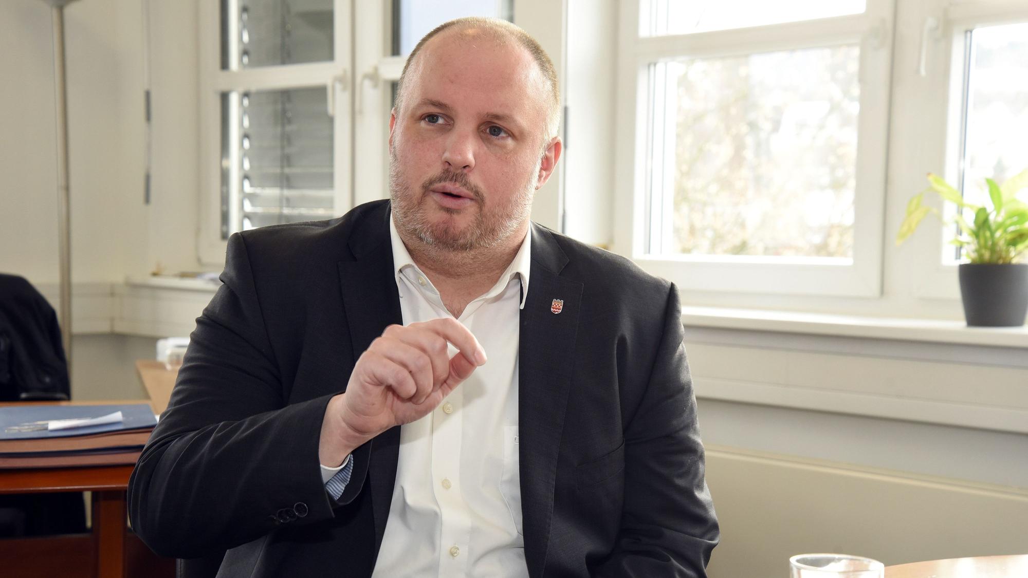 Ein Mann sitzt in einem Büro an einem Tisch.
