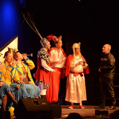 Premiere der alternativen Sitzung in der Abenteuerhalle Kalk. Schauspieler stehen in Kostümen auf der Bühne.