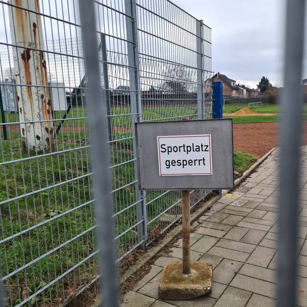 Auf dem Foto ist der Rasenplatz des Jahnstadions in Bergheim zu sehen. Auf einem Schild ist zu lesen "Sportplatz gesperrt".