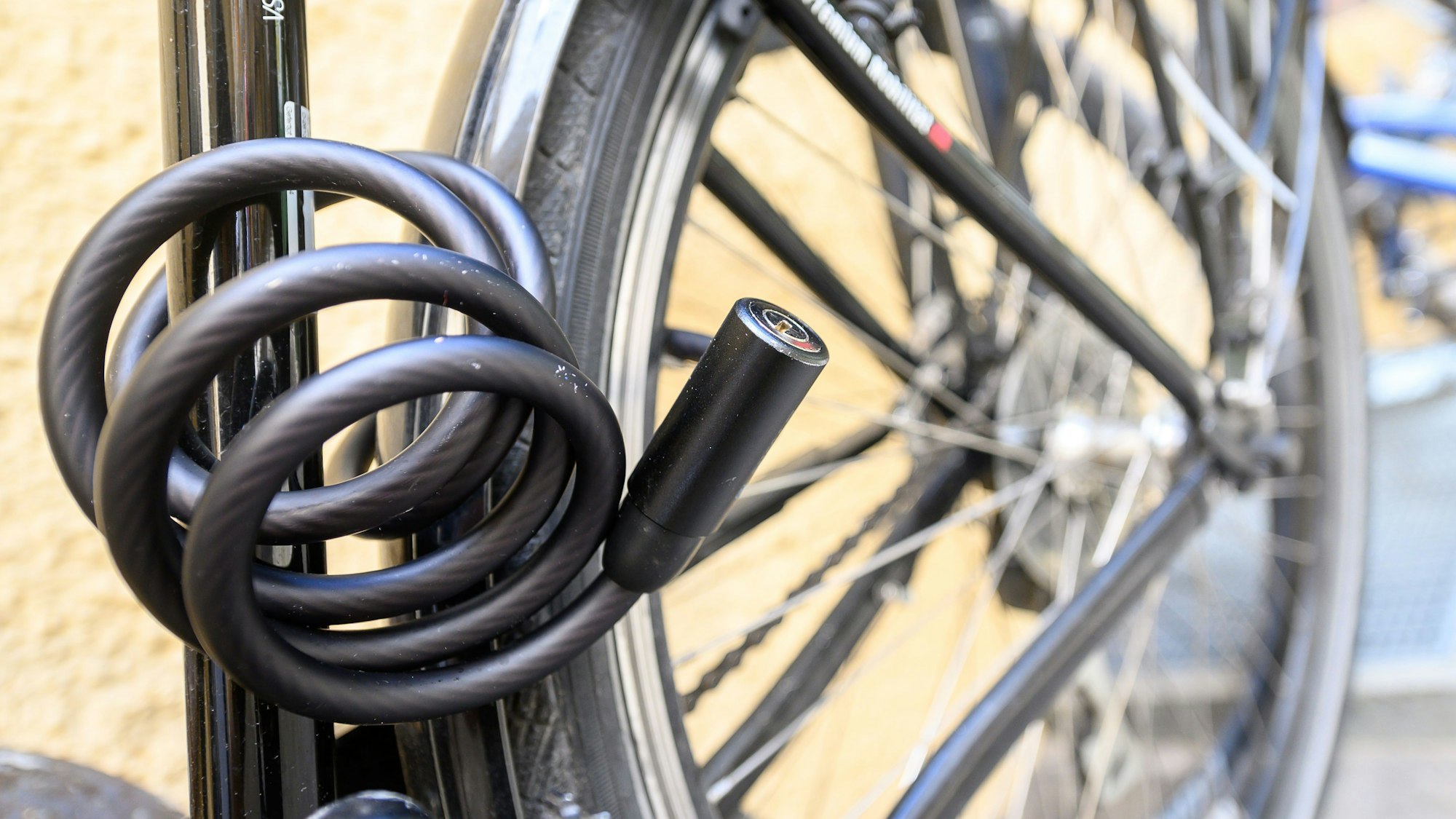 Ein Fahrrad ist in einem Hinterhof mit einem Schloss angeschlossen.