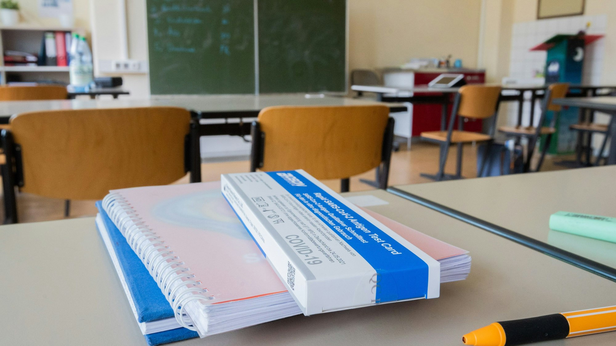 Ein Corona-Selbsttest liegt am Platz eines Schülers in einem Klassenraum.