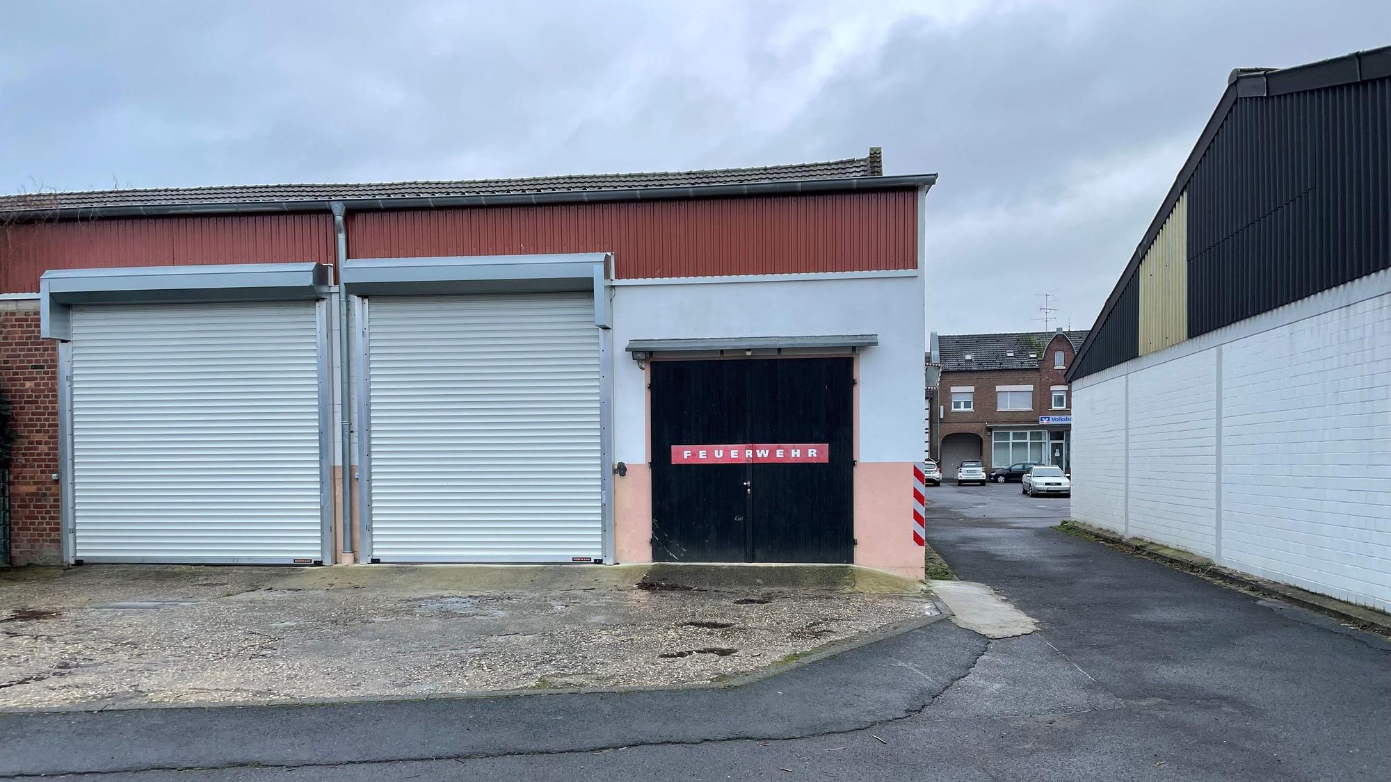 Die Tore am Feuerwehrgerätehaus in Lommersum sind verschlossen. Rechts ist die schmale Gasse zu sehen, durch die die Feuerwehrfahrzeuge fahren müssen.