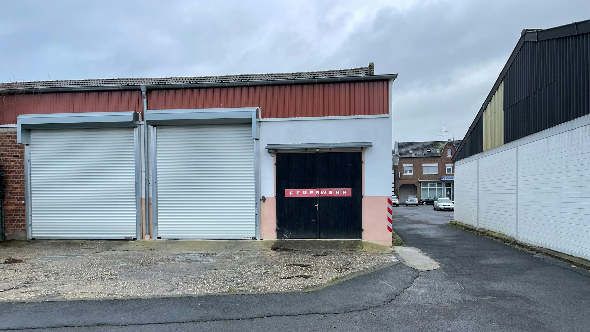 Die Tore am Feuerwehrgerätehaus in Lommersum sind verschlossen. Rechts ist die schmale Gasse zu sehen, durch die die Feuerwehrfahrzeuge fahren müssen.