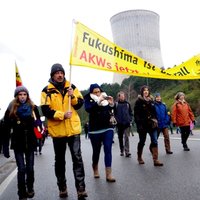 Das Archivfoto zeigt Demonstranten mit einem Transparent gegen Atomkraft vor dem Atomkraftwerk Tihange.