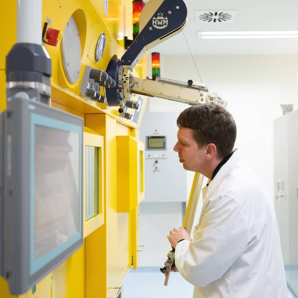 Ein Arzt steht in einem Labo an einer sogenannten Heißen Zelle zur Arbeit an radioaktiven Substanzen.