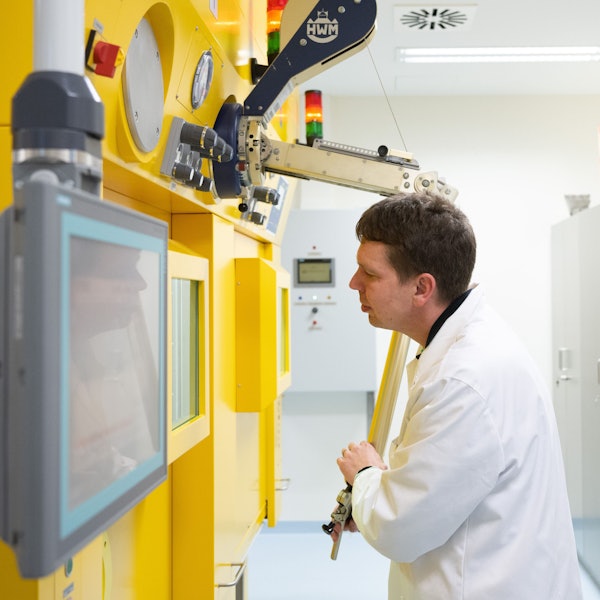 Ein Arzt steht in einem Labo an einer sogenannten Heißen Zelle zur Arbeit an radioaktiven Substanzen.