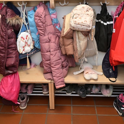 Jacken und Mäntel hängen an einer Garderobe in einer Kita.