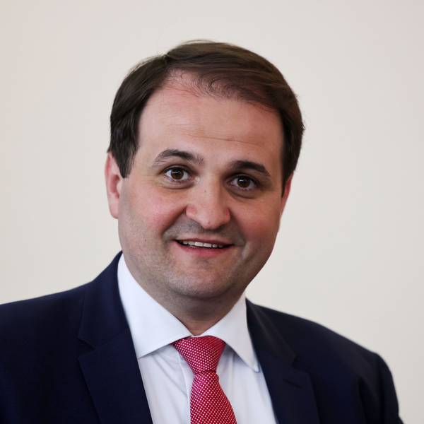 Nathanael Liminski (CDU), Chef der Staatskanzlei des Landes Nordrhein-Westfalen, steht vor einer weißen Wand. Er trägt einen blauen Anzug.