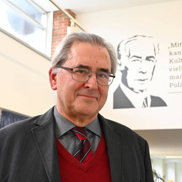 Klaus Füßmann steht vor einem Zitat von Theodor Heuss an einer Wand. Das Zitat lautet: „Mit Politik kann man keine Kultur machen, vielleicht kann man mit Kultur Politik machen.“