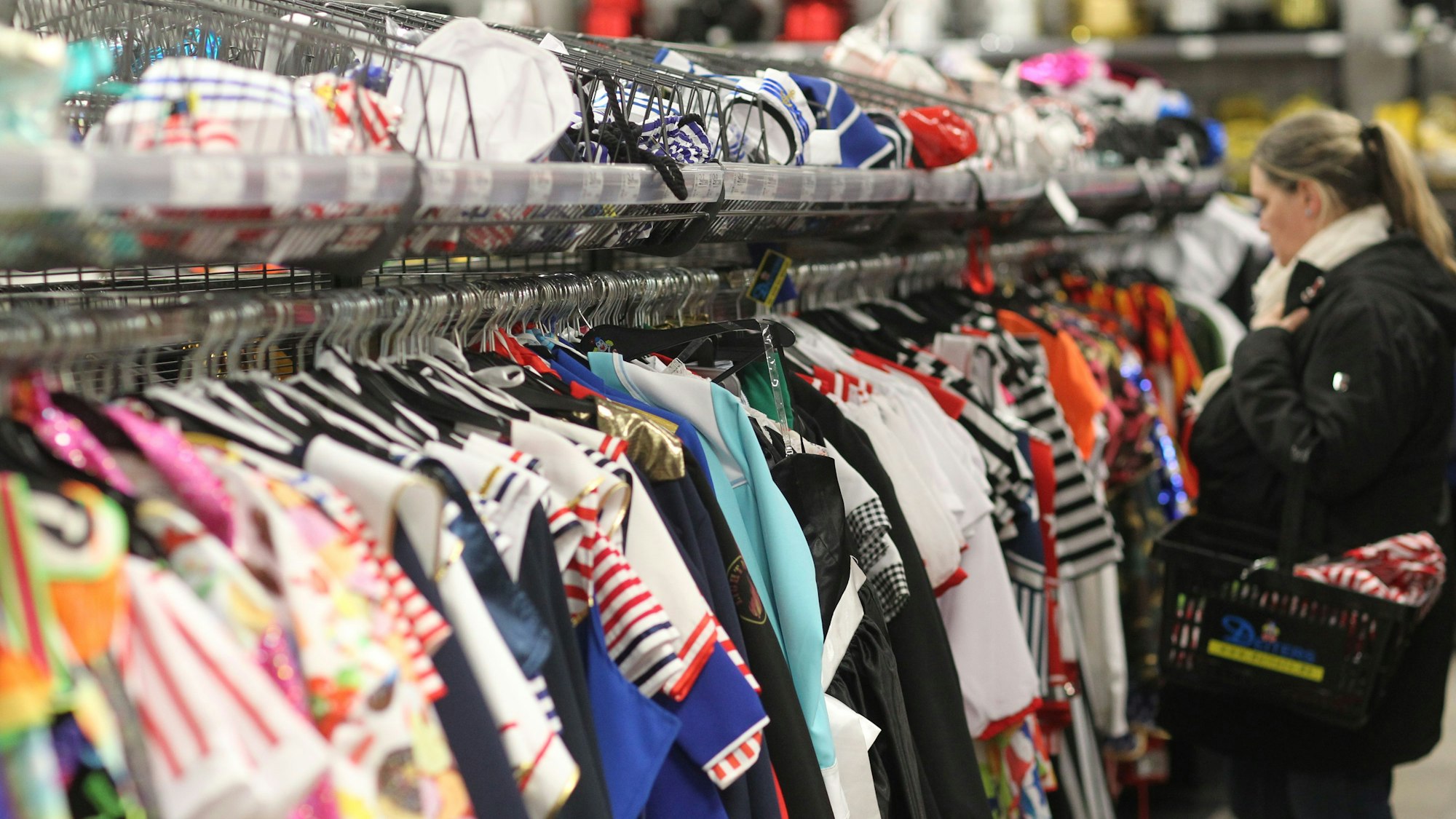 Eine Frau kauft in einem Karnevalsgeschäft ein.