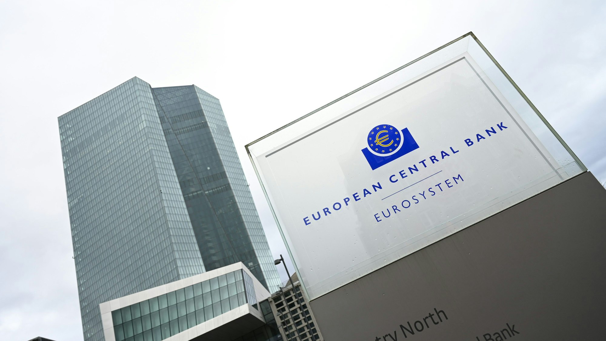 Eine Stele mit der Inschrift «European Central Bank Eurosystem» steht vor der Zentrale der Europäischen Zentralbank (EZB).
