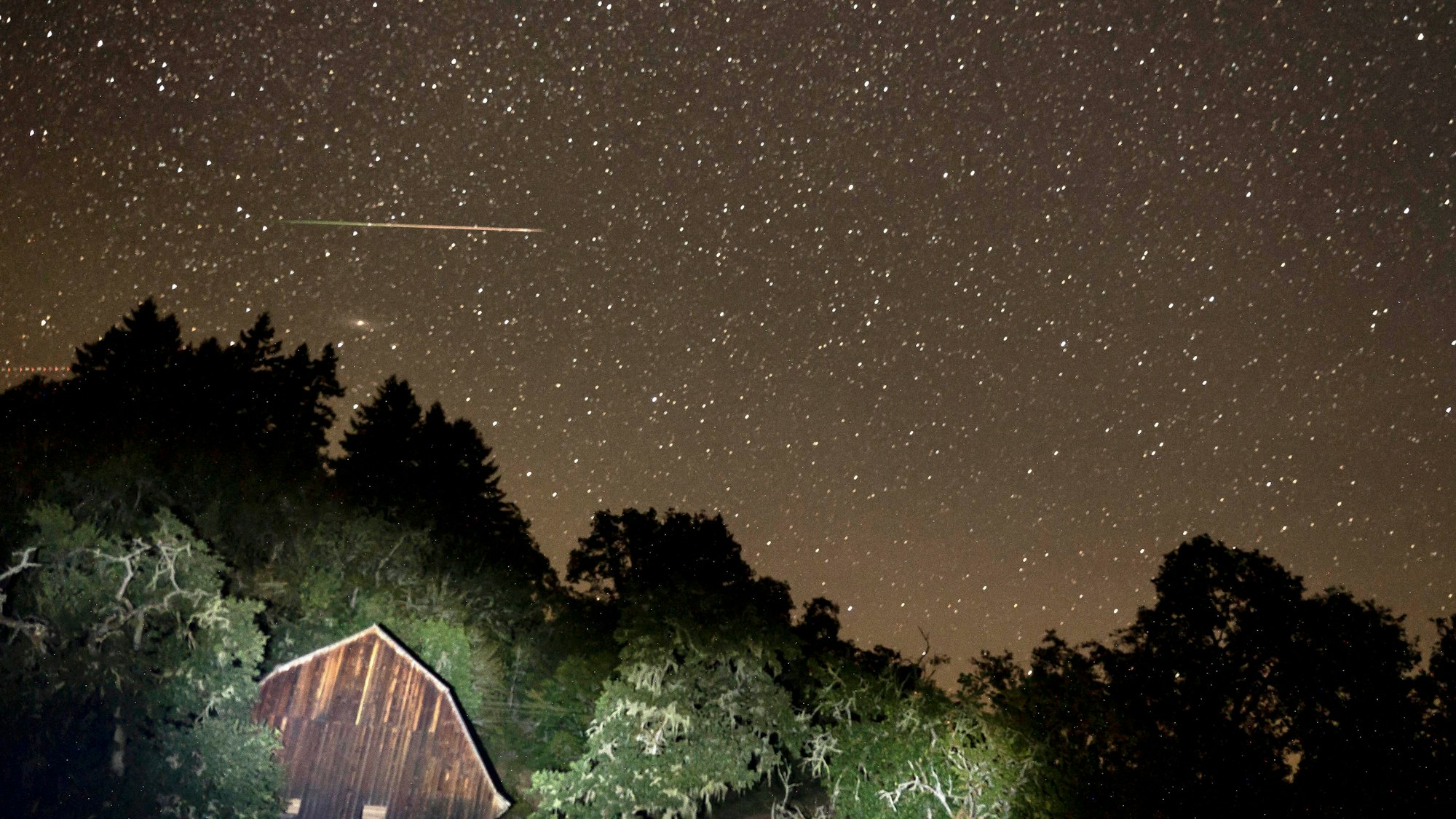 Ein Meteorit des Perseiden-Meteoritenschauers zieht am Himmel über einer Scheune an einer Landstraße im ländlichen Westen Oregons vorbei. (Symbolbild)