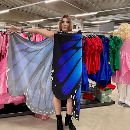 Eine Frau präsentiert blau-schwarze Schmetterlingsflügel für eine Karnevalsverkleidung