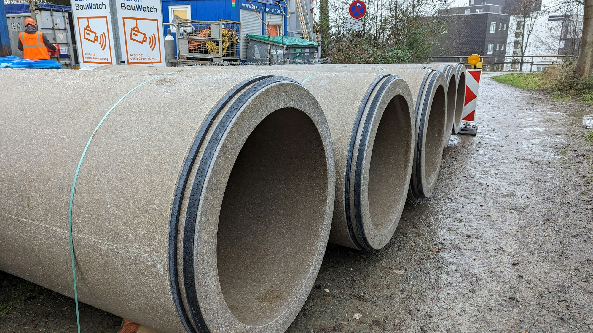 Fünf Betonrohre mit einem Durchmesser von jeweils einem Meter liegen auf schlammigem Untergrund.