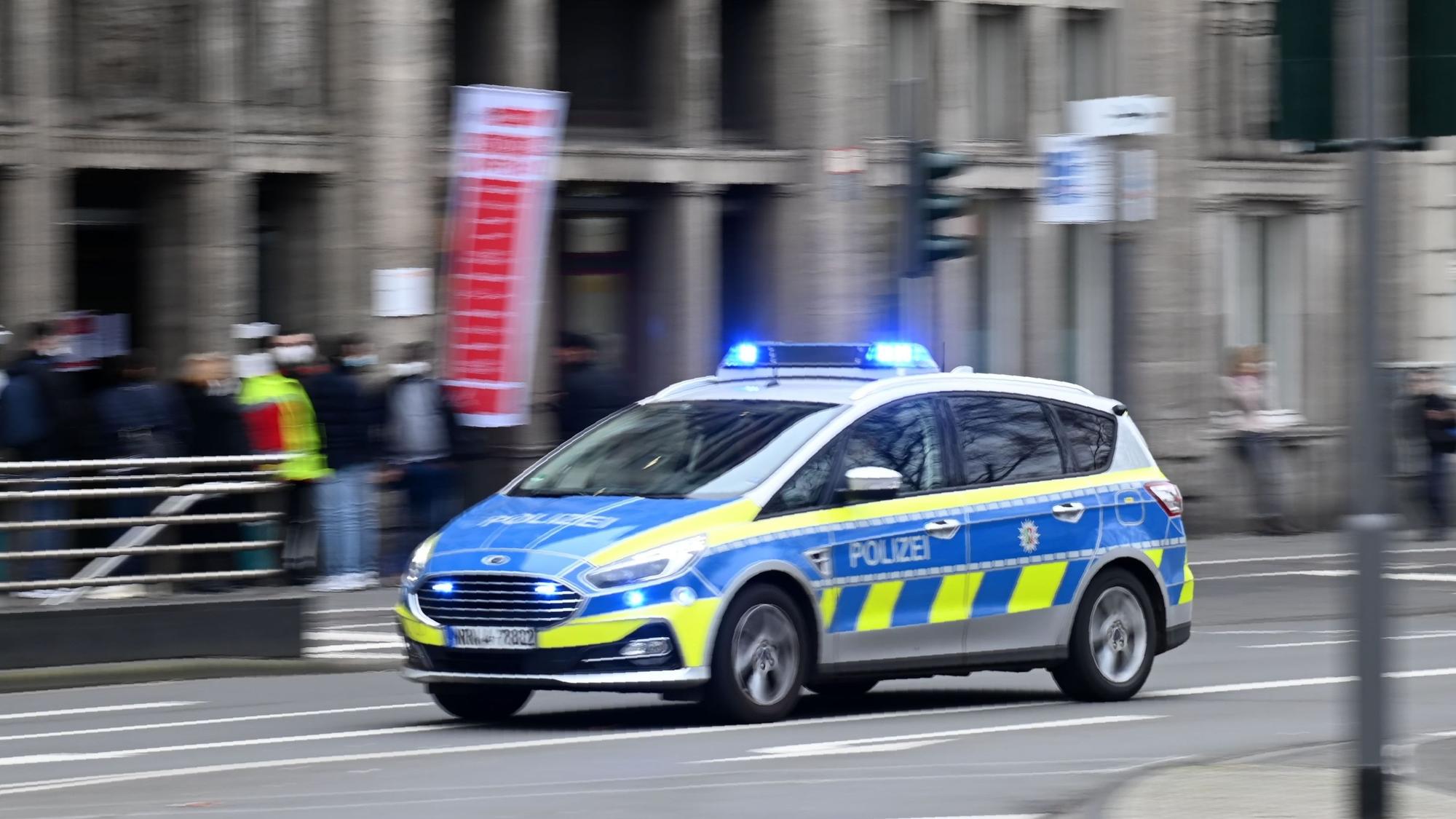 Ein Polizeiauto fährt auf der Straße - die Aufnahme ist verwackelt.