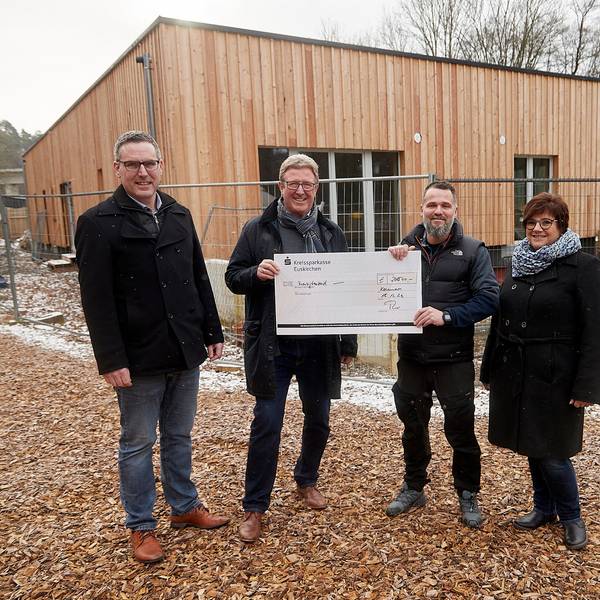Mitglieder des Rotary-Club Euskirchen-Burgfey, Kindergartenleitung und der Bürgermeister stehen vor dem neuen Gebäude im Waldkindergarten.