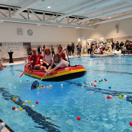 Bällchen-Angeln bei der Hallenbad-Eröffnung: Im DLRG-Schlauchboot sitzt in der Mitte Geschäftsführerin Alice Bosch.