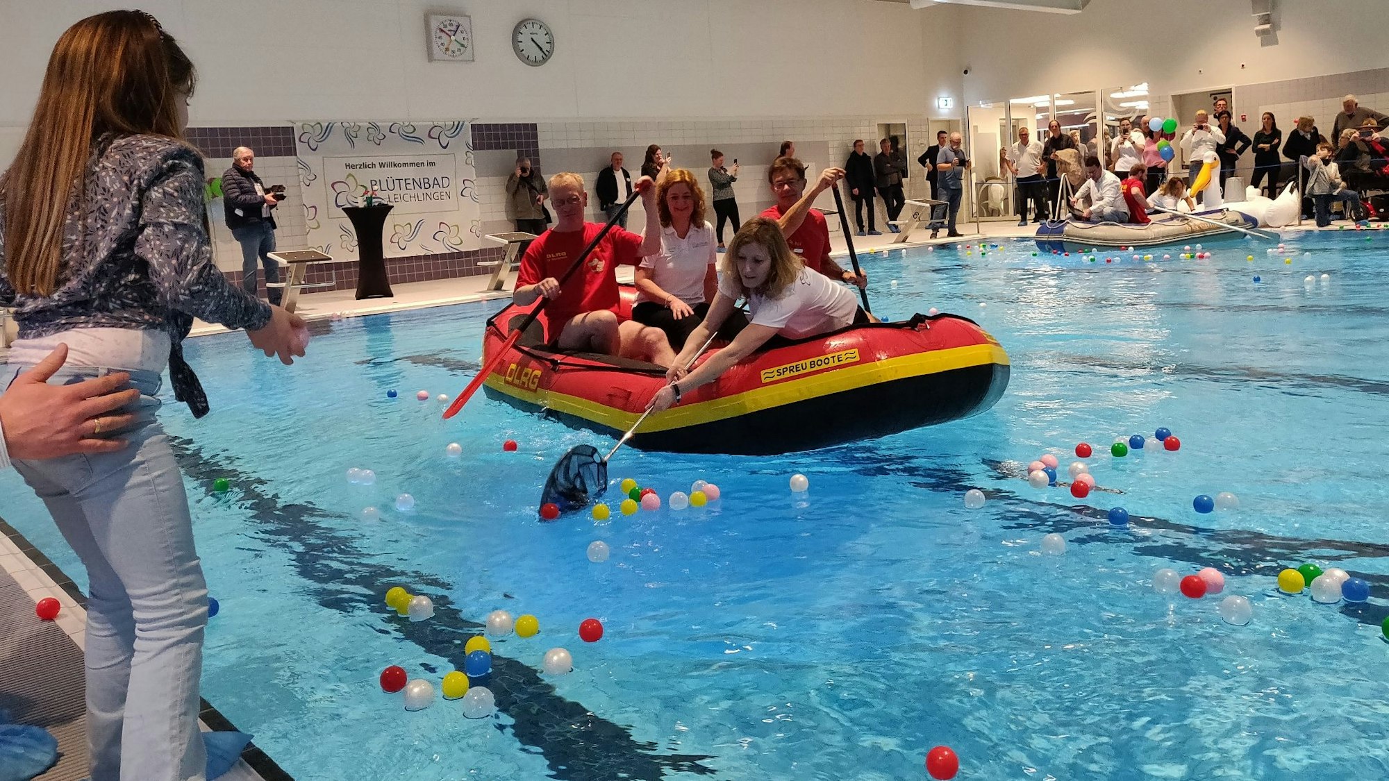 Bällchen-Angeln bei der Hallenbad-Eröffnung: Im DLRG-Schlauchboot sitzt in der Mitte Geschäftsführerin Alice Bosch.