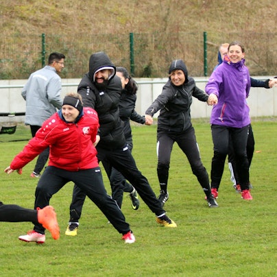 Teilnehmer des Lehrgangs spielen auf dem Rasenplatz in Kirchheim fangen.