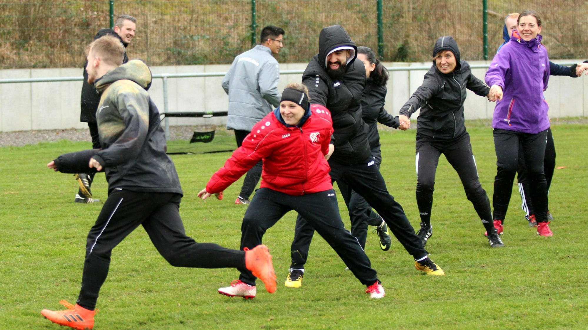 Teilnehmer des Lehrgangs spielen auf dem Rasenplatz in Kirchheim fangen.