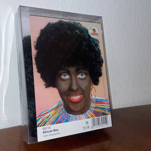 Eine Karnevalsperücke eines Kölner Kostümhändlers steht in der Kritik. Der Produktname „African Boy“ und die Beschminkung der Person haben eine rassistische Geschichte und bringen deshalb Empörung hervor.