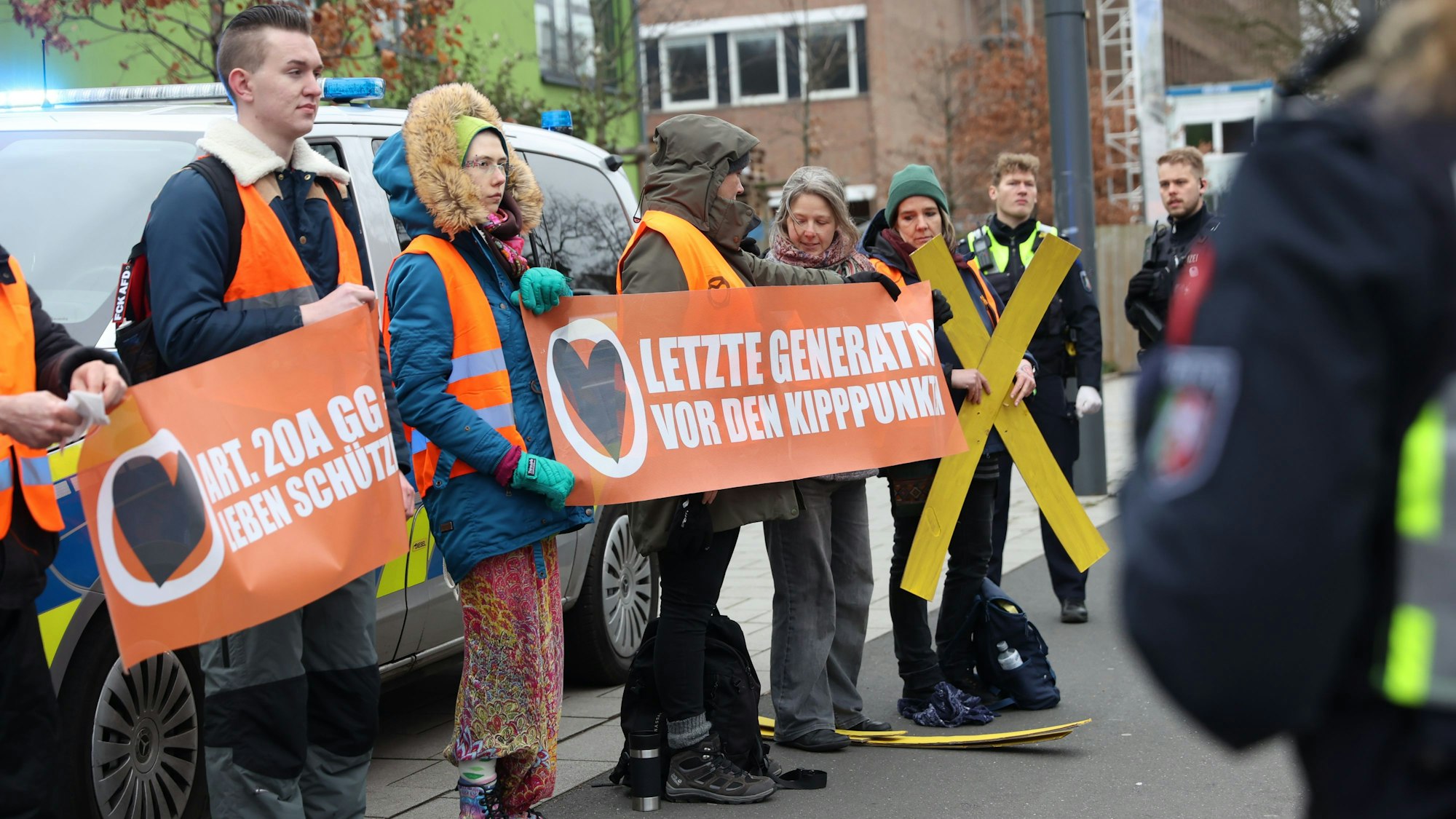 Aktivisten der „Letzten Generation“ bei einer Protestaktion an der Universitätsstraße in Köln.