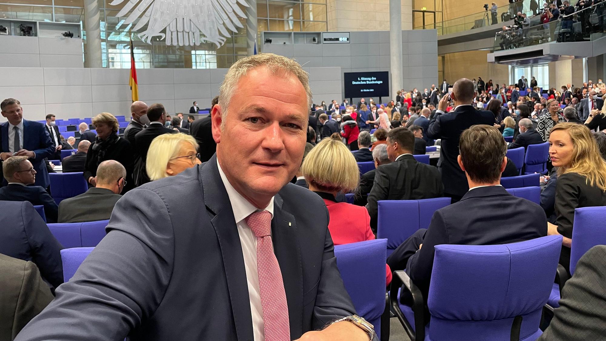 Dr. Carsten Brodesser sitzt im Plenarsaal des Bundestages in Berlin.