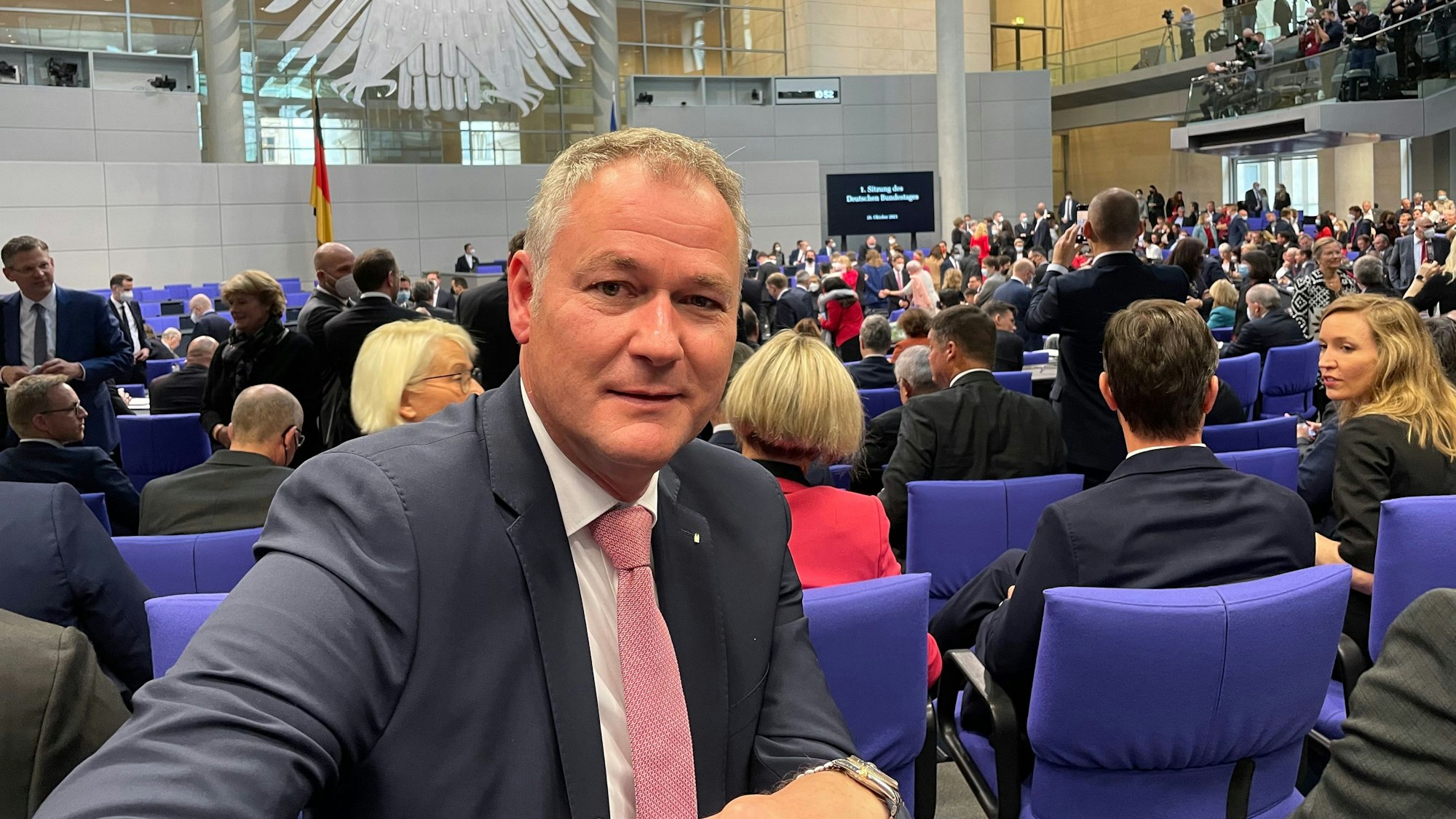 Dr. Carsten Brodesser sitzt im Plenarsaal des Bundestages in Berlin.