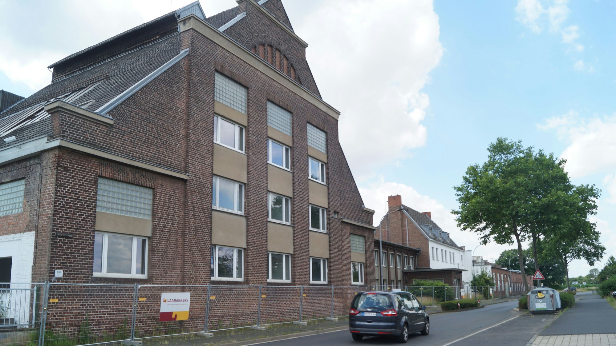 Altes Fabrikgebäude mit Bauzäunen umringt