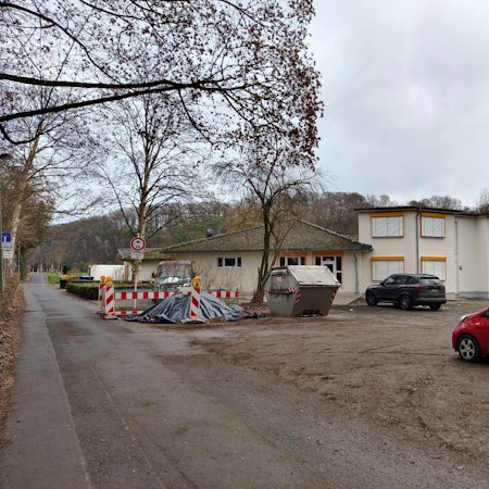 Auf dem Parkplatz vor den Kitas Am Hammer stehen Autos und lagert Baumaterial.