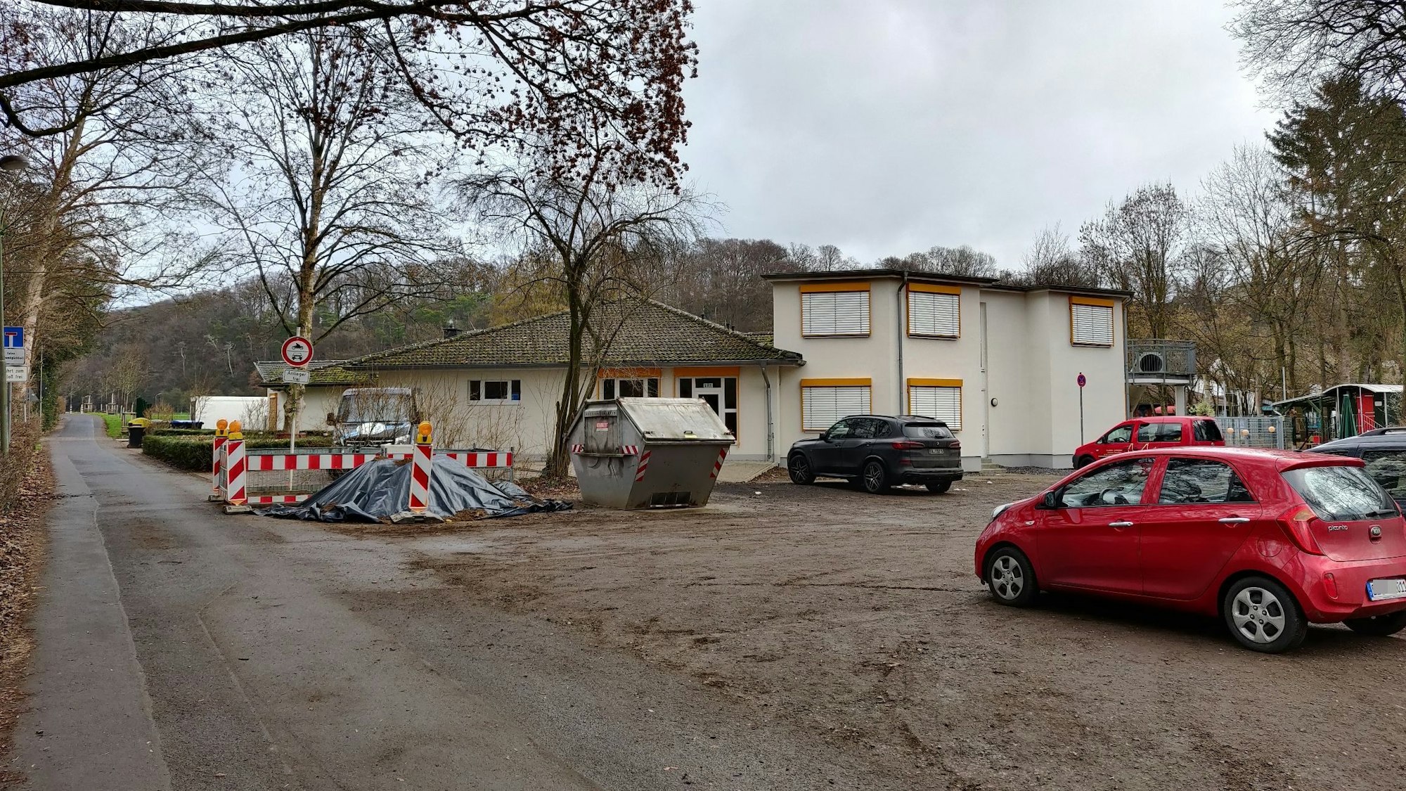 Auf dem Parkplatz vor den Kitas Am Hammer stehen Autos und lagert Baumaterial.