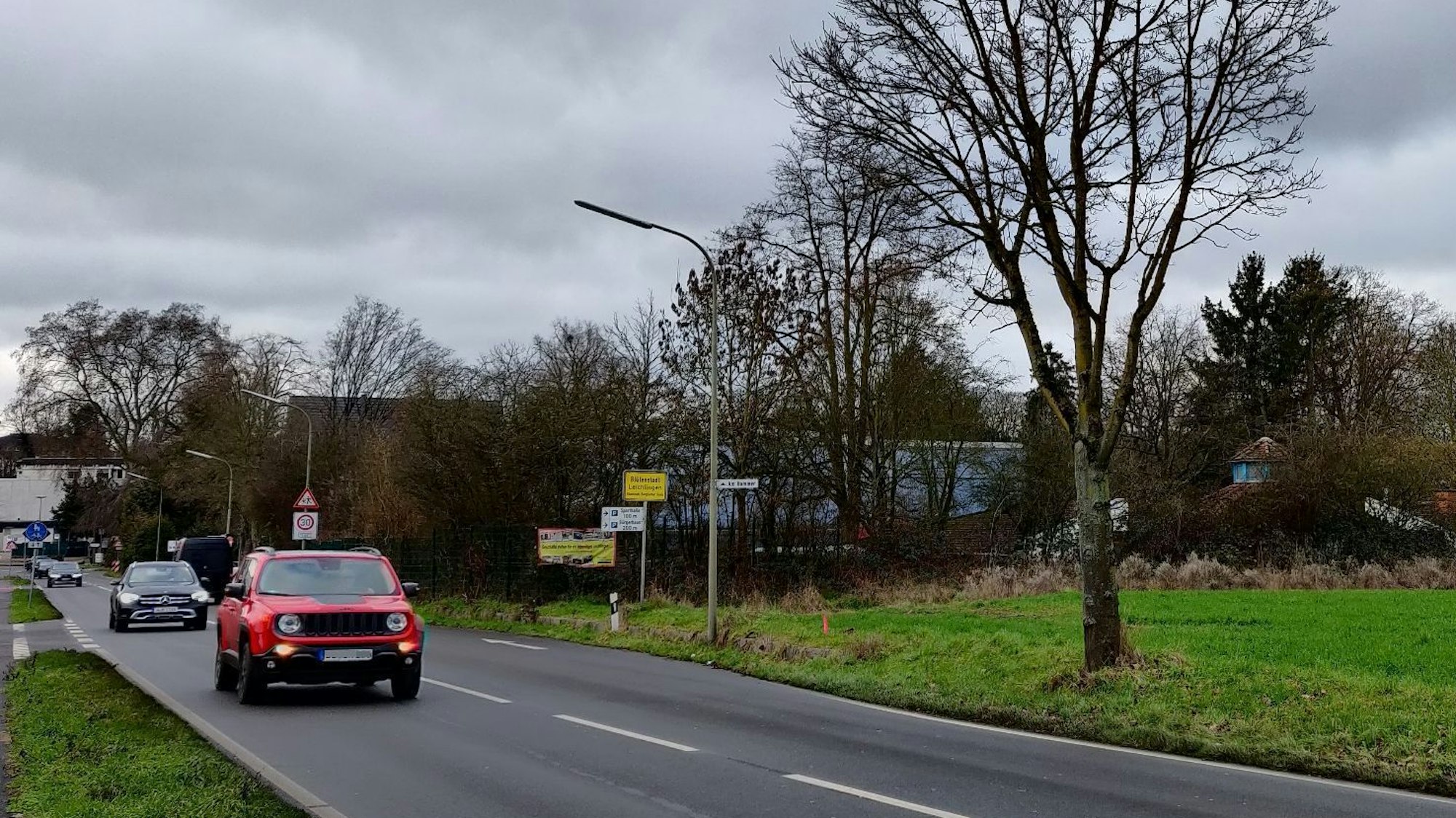Autos fahren auf der Kreisstraße Am Hammer in Höhe des Ortseingangs.