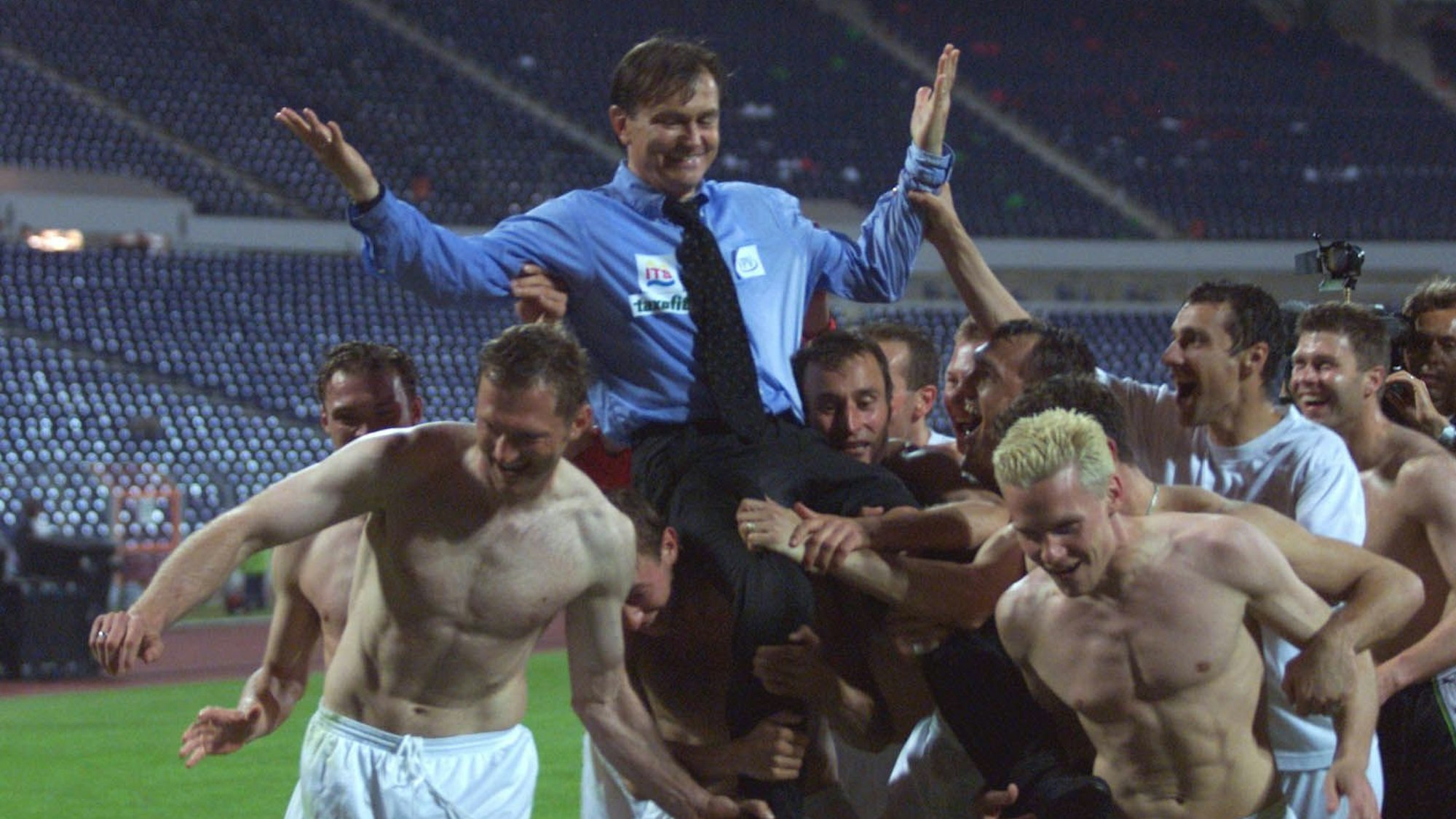 Die Spieler des 1. FC Köln heben ihren Trainer Ewald Lienen hoch.