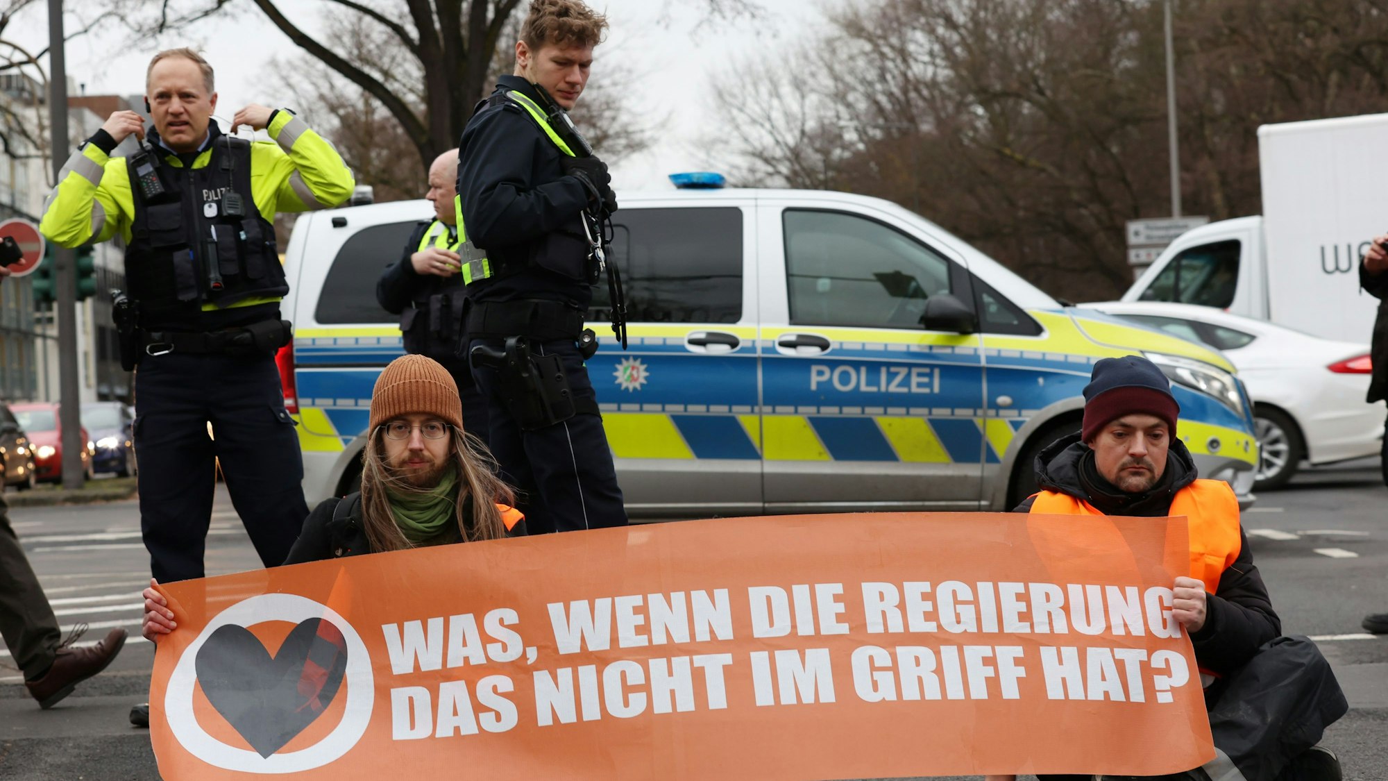 Aktivisten der „Letzten Generation“ blockieren in Köln auf der Universitätsstraße Ecke Bachemer Straß zur Hauptverkehrszeit am frühen Morgen den Verkehr.