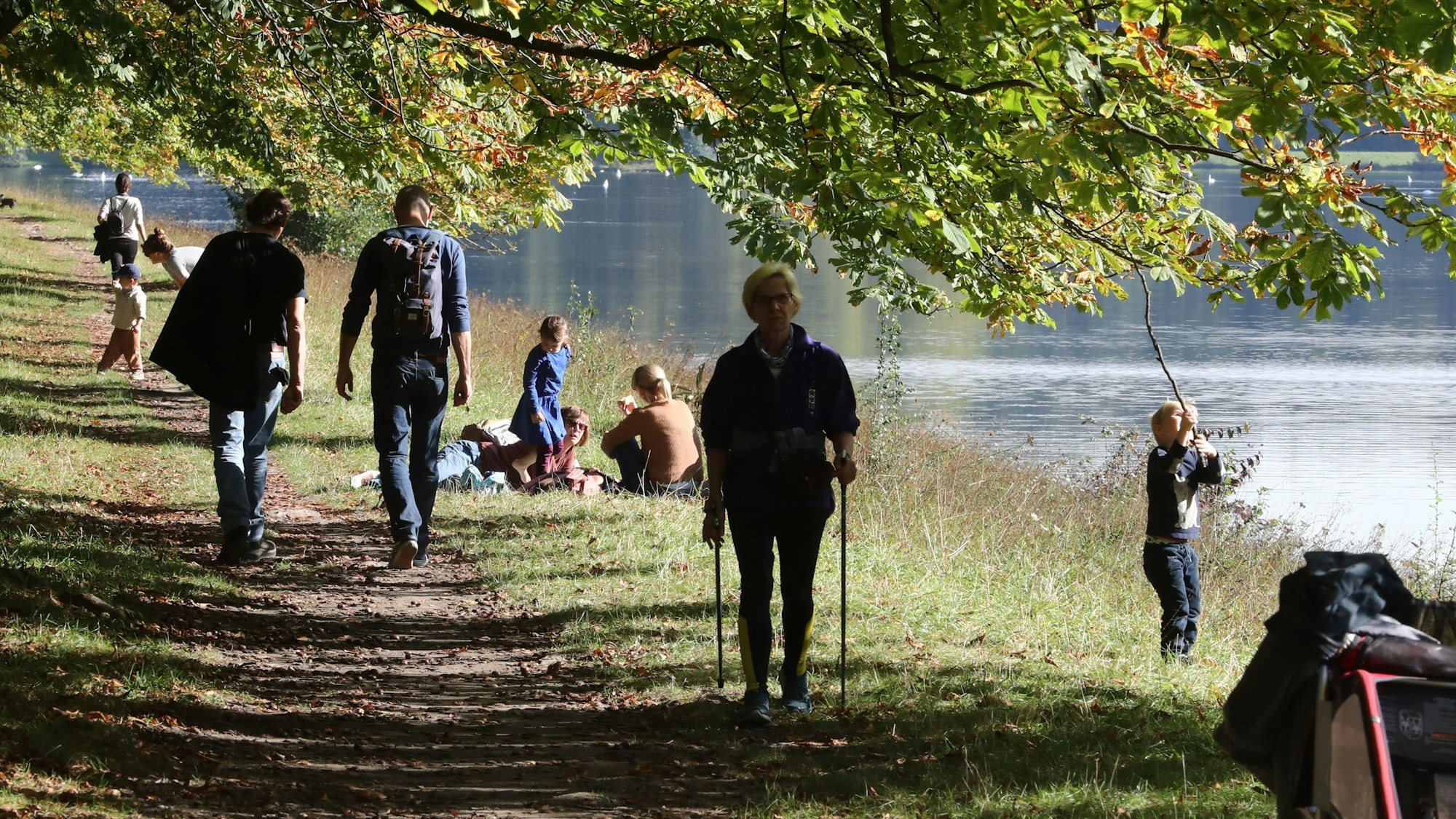 Sonnenschein im Grüngürtel mit Fußgängern, Fußgängerinnen und Kindern