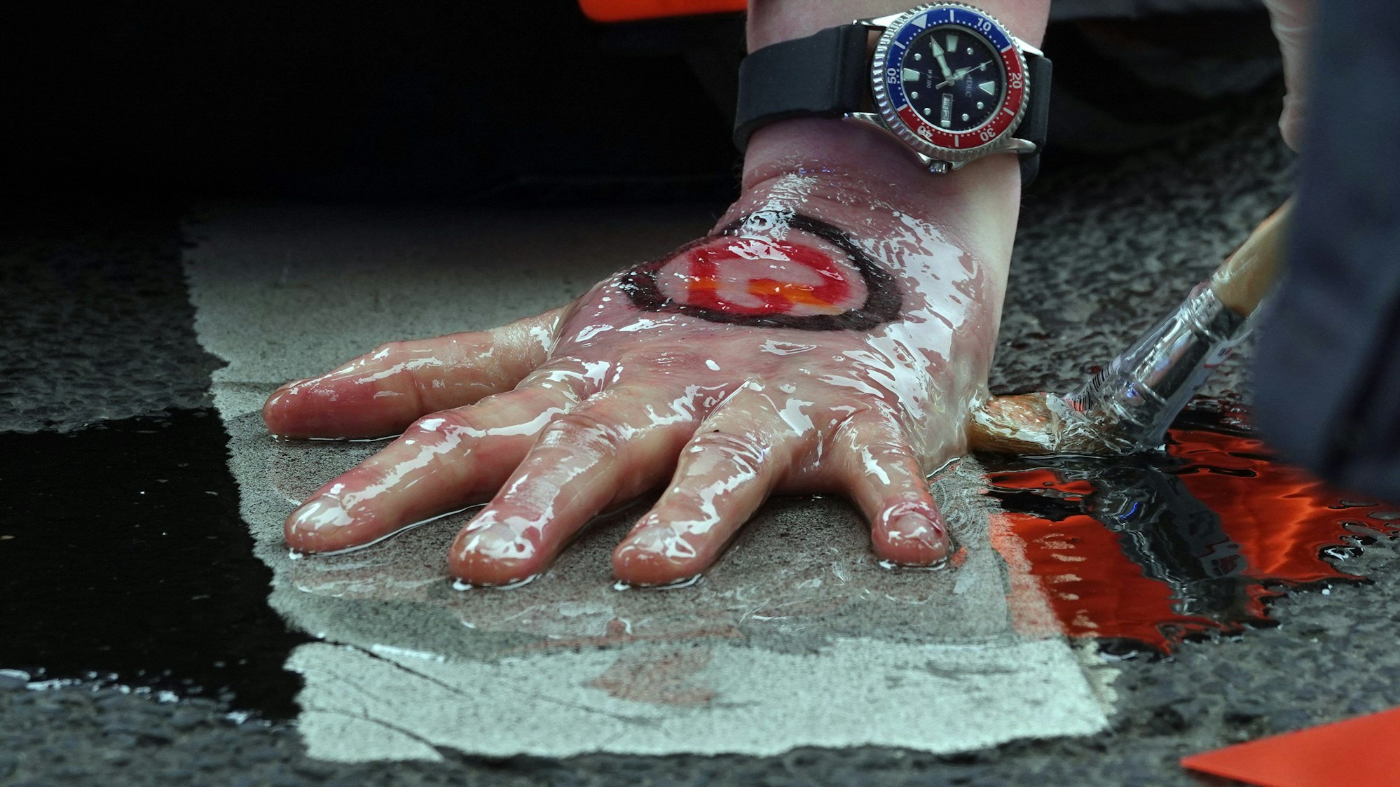 Polizisten lösen die festgeklebte Hand eines Aktivisten der Umweltgruppe «Letzte Generation» von der Fahrbahn.