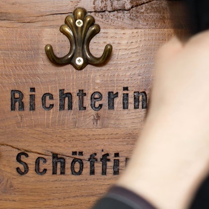 Ein Richter hängt seine Robe an eine Garderobe für Richter und Schöffen